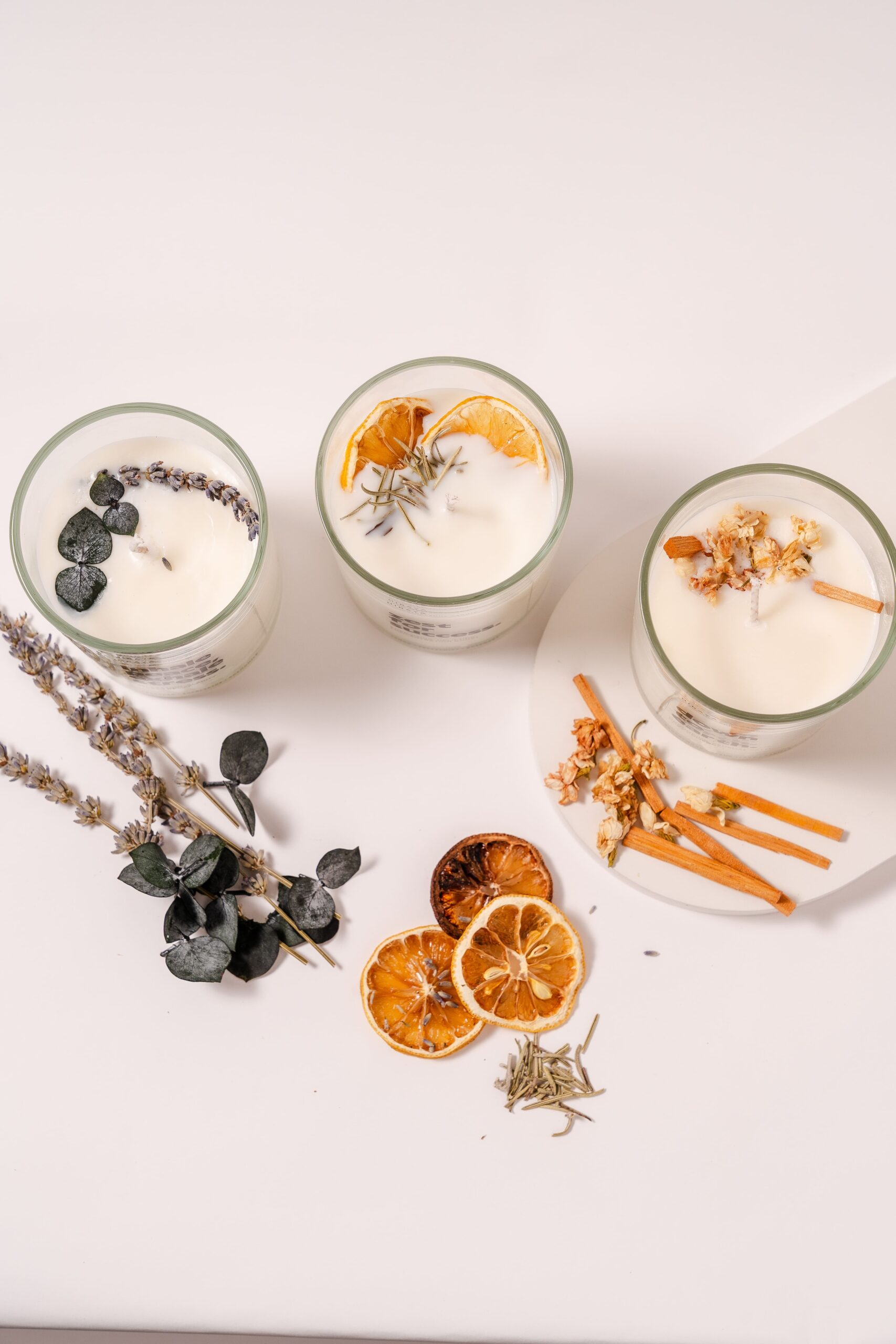 Top shot of full aromatherapy candle collection showing dried lavender, citrus, herbs, and floral toppings for each scent