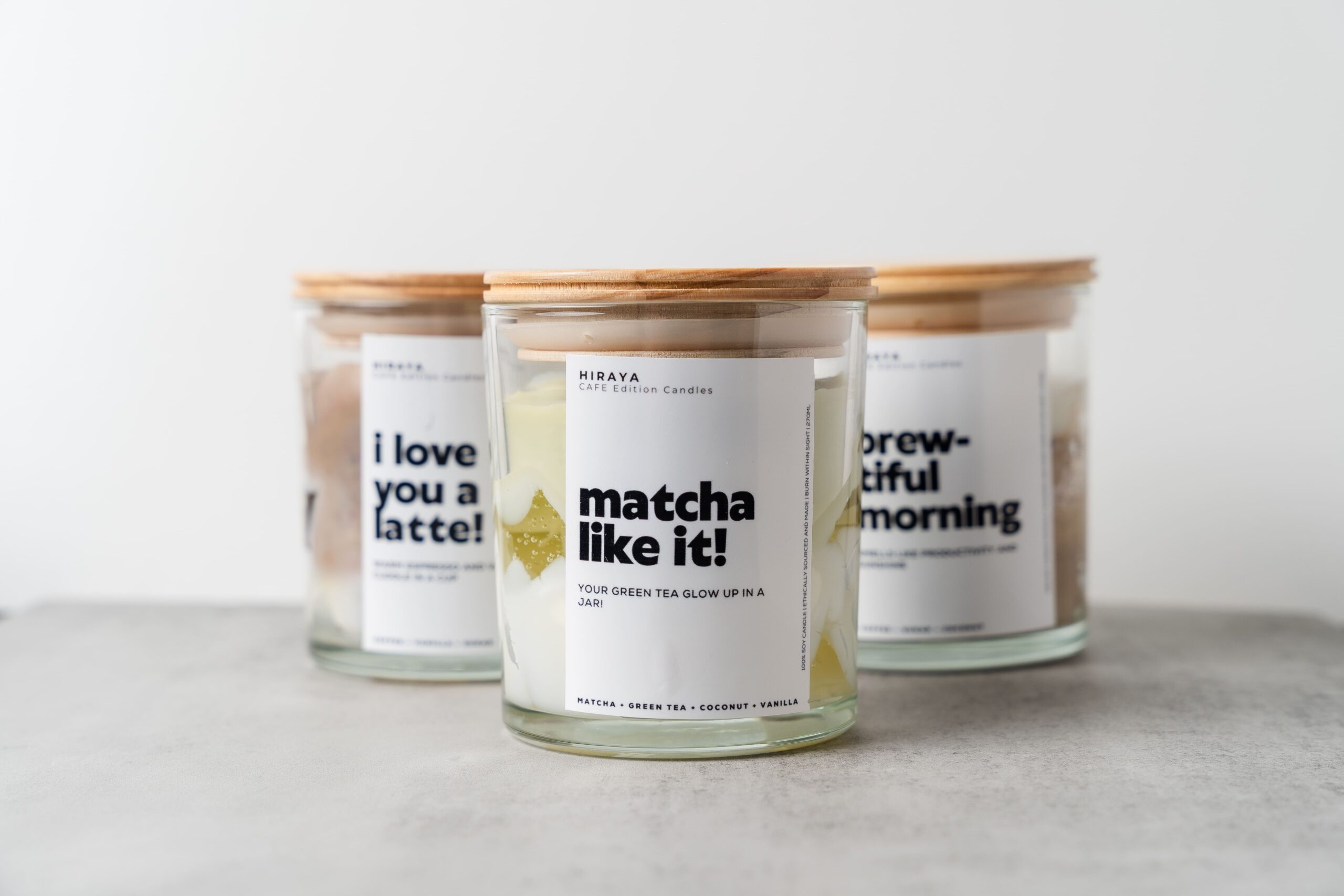 Styled display of the Matcha Like It! candle with matcha, coconut, and vanilla elements representing its calm, mindful fragrance.