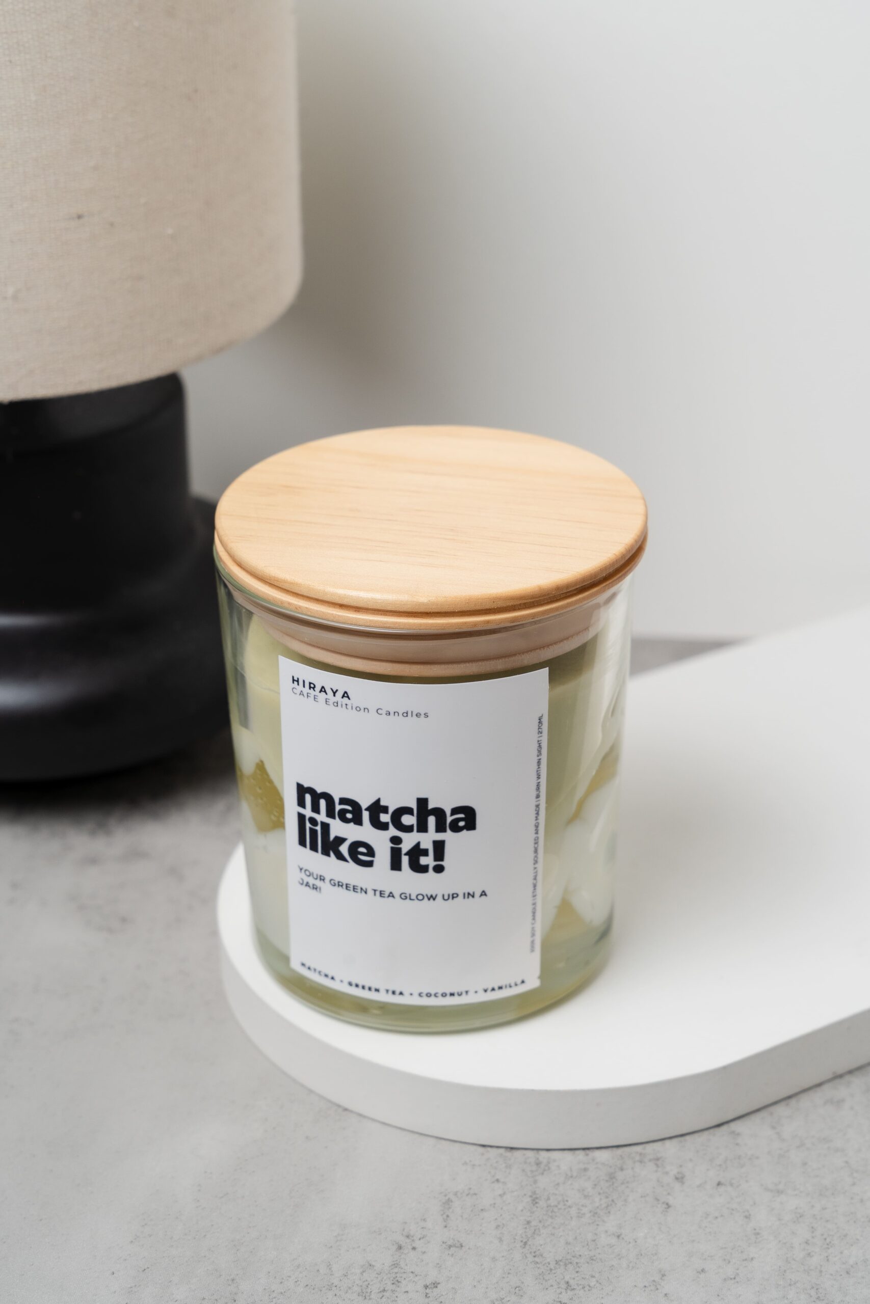 Close‑up with wooden lid of the Matcha Like It! candle highlighting the creamy wax texture and matcha‑inspired label design.
