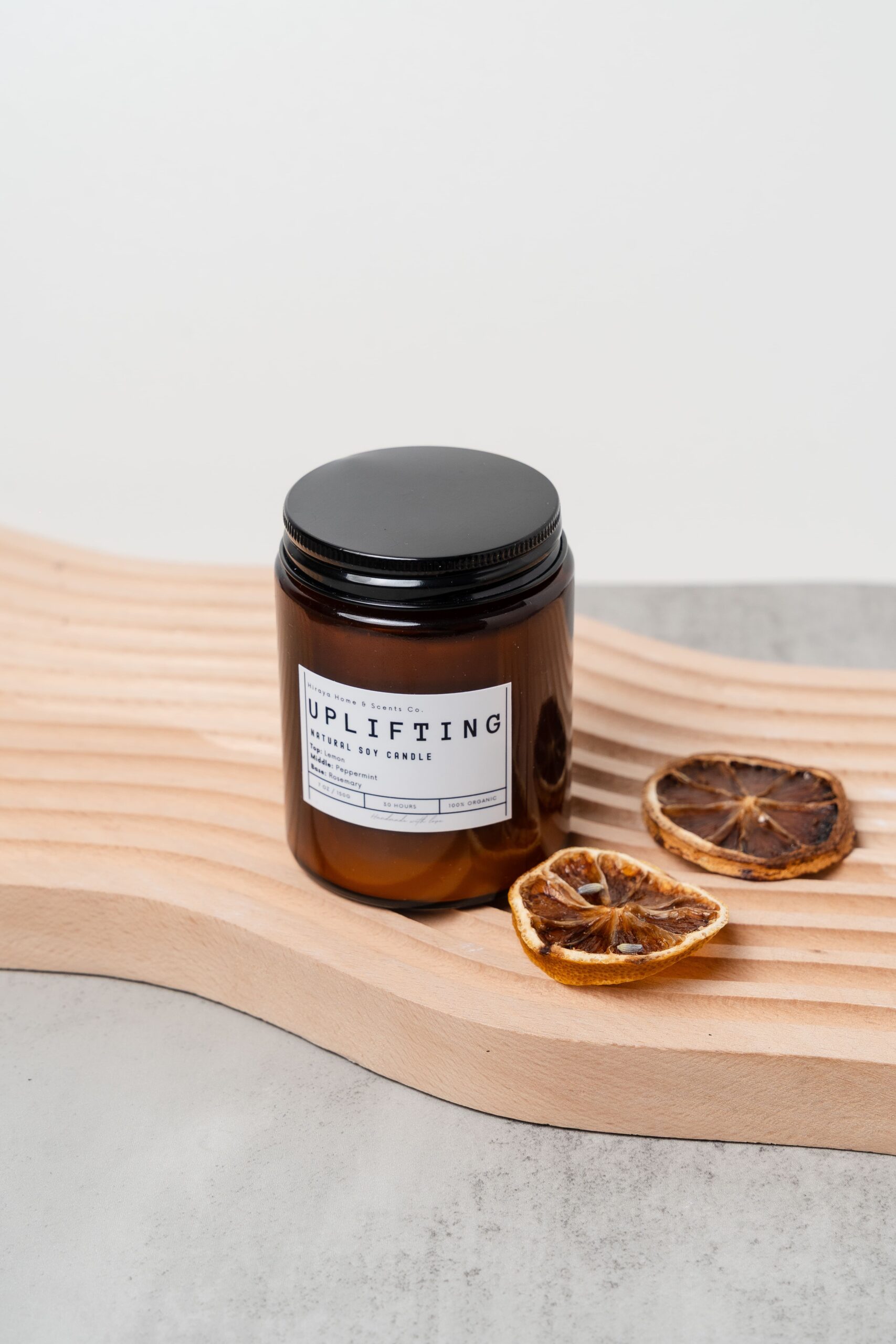 Front view of the Uplifting candle with lemon‑peppermint‑rosemary label in a 150ml amber jar.