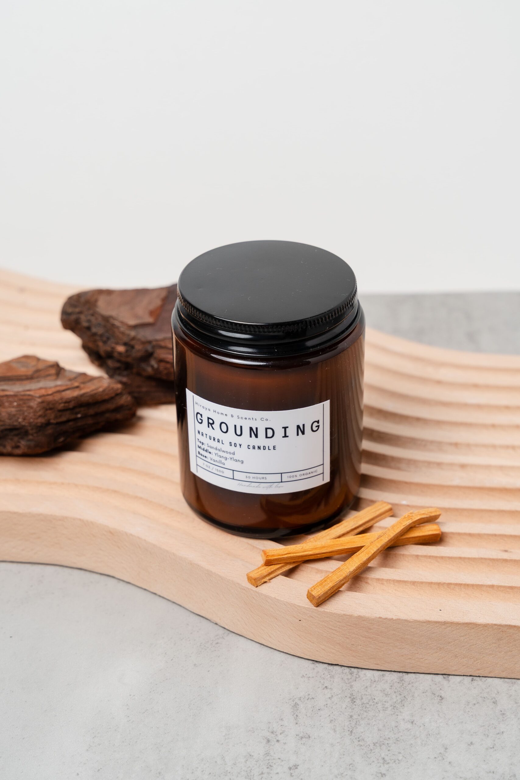 Front view of the Grounding candle with sandalwood‑ylang‑ylang‑vanilla label in a 150ml amber jar.
