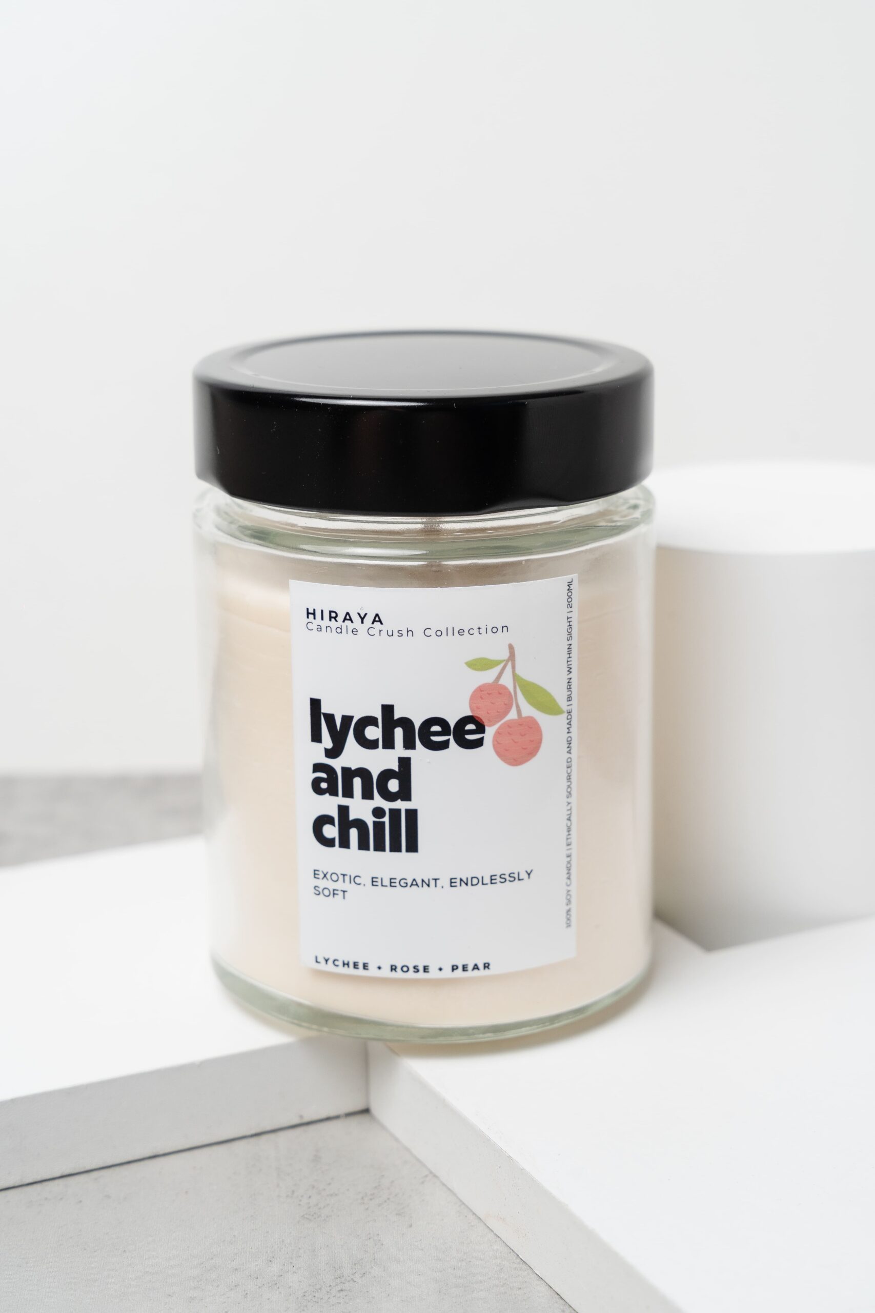 Close‑up showing wax texture and delicate lychee‑rose label details.
