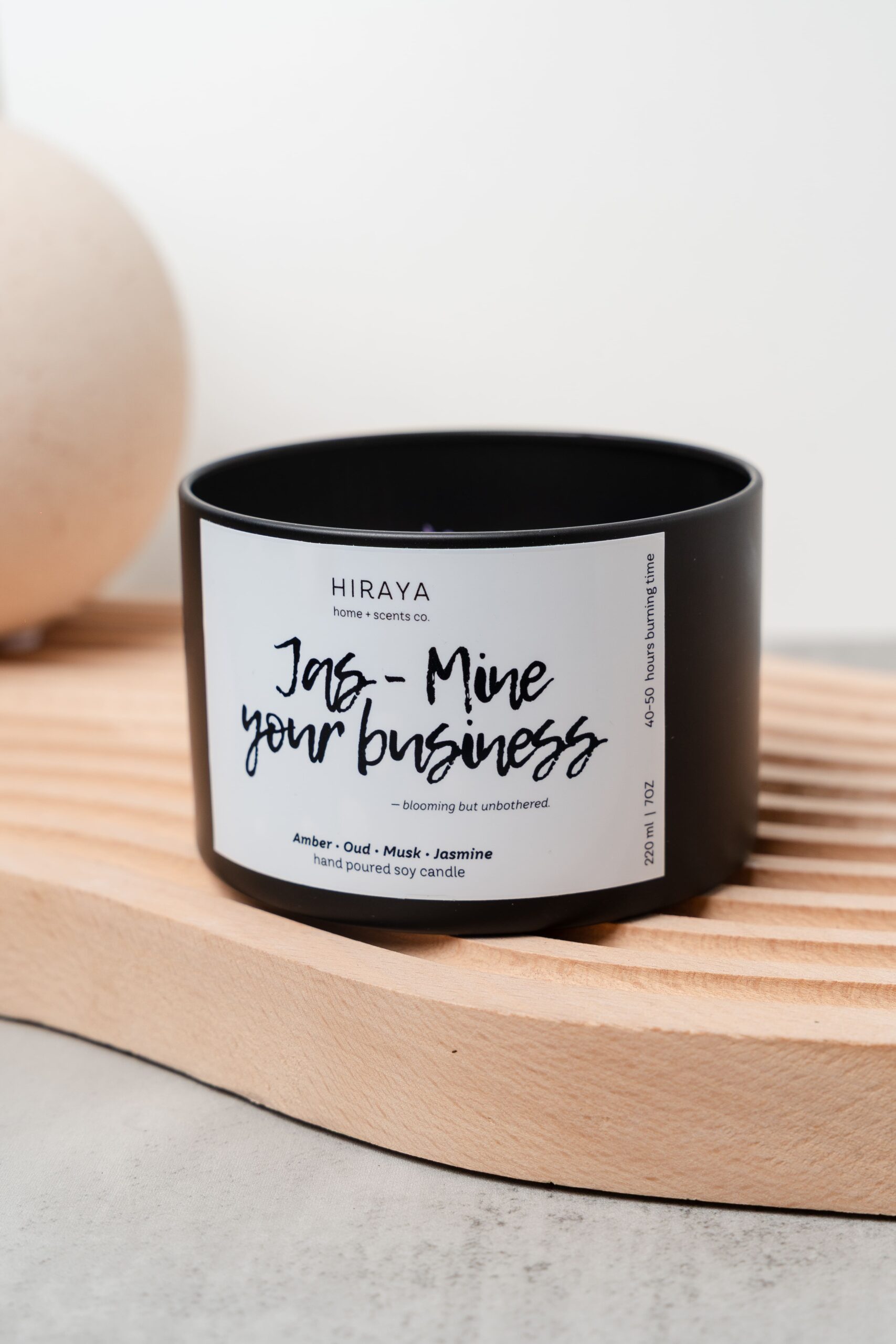 Close‑up of the Jas‑Mine Your Business candle showing wax texture and luminous jasmine‑inspired label details.