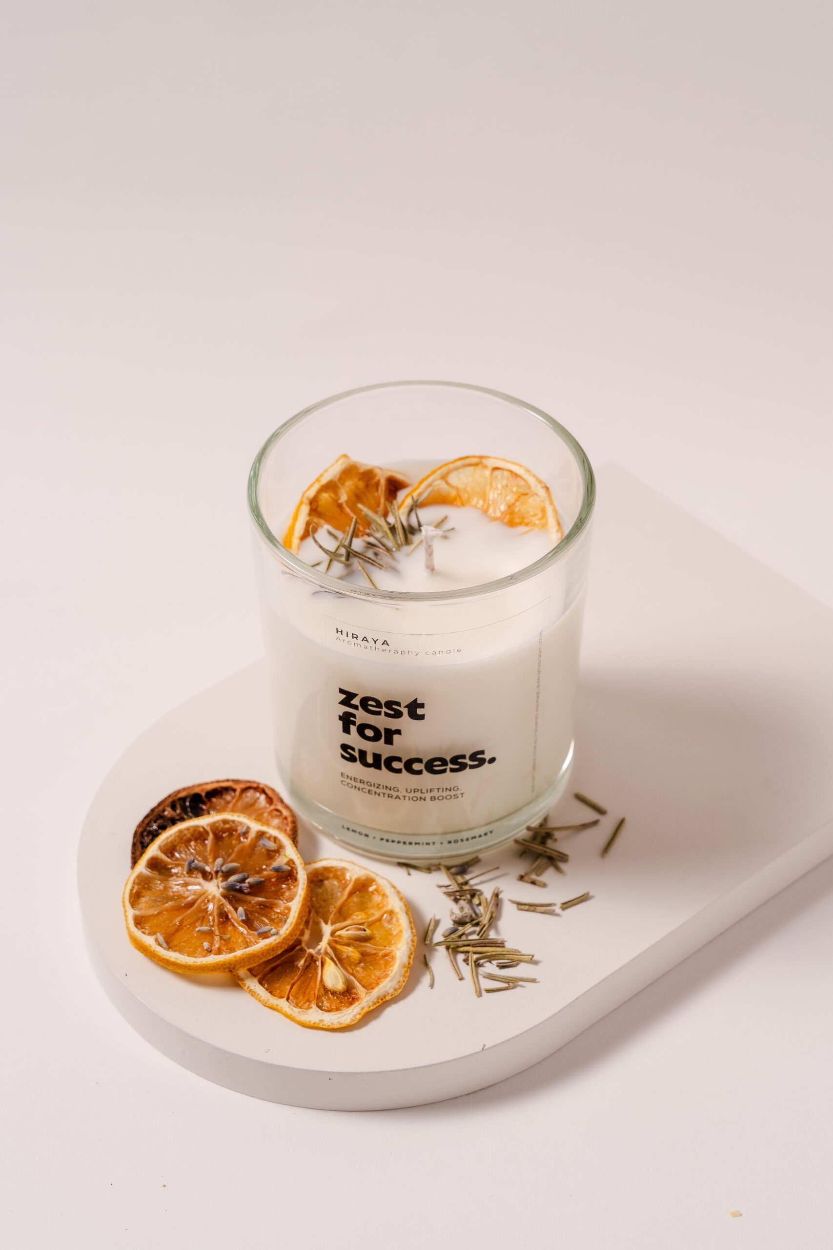 Top view of lemon, peppermint, and rosemary candle showing dried citrus and herbal toppings